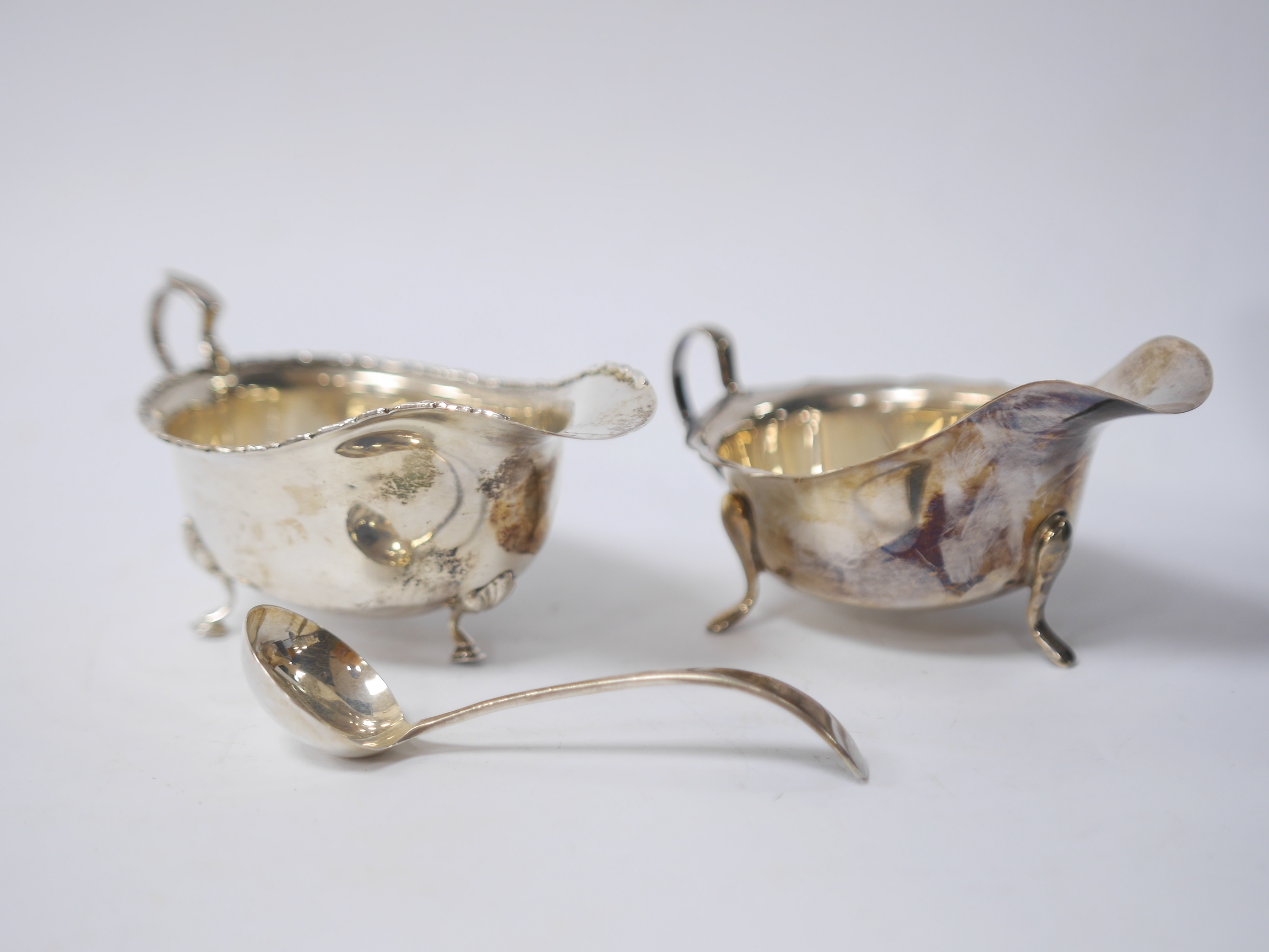 A cased Elizabeth II silver sauce boat and spoon, by Viners Ltd, Sheffield, 1952/5 and one other silver sauce boat. Condition - poor to fair